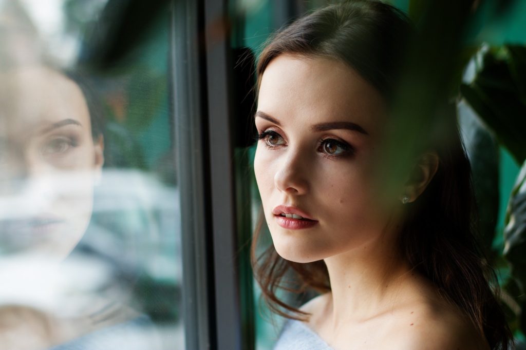 Young woman looking out a window.